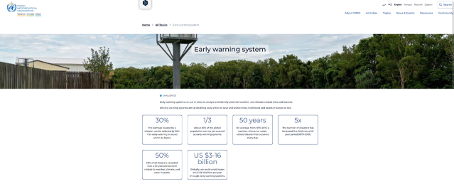 A tall early warning watchtower overlooking a forested area under a cloudy sky on a WHO webpage titled "Early warning system" with statistics about disaster risk reduction.