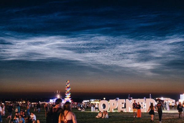 Crowd of people at an outdoor evening festival with large illuminated