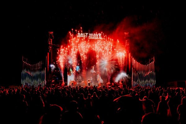 Concert stage with a band performing under red fireworks and 