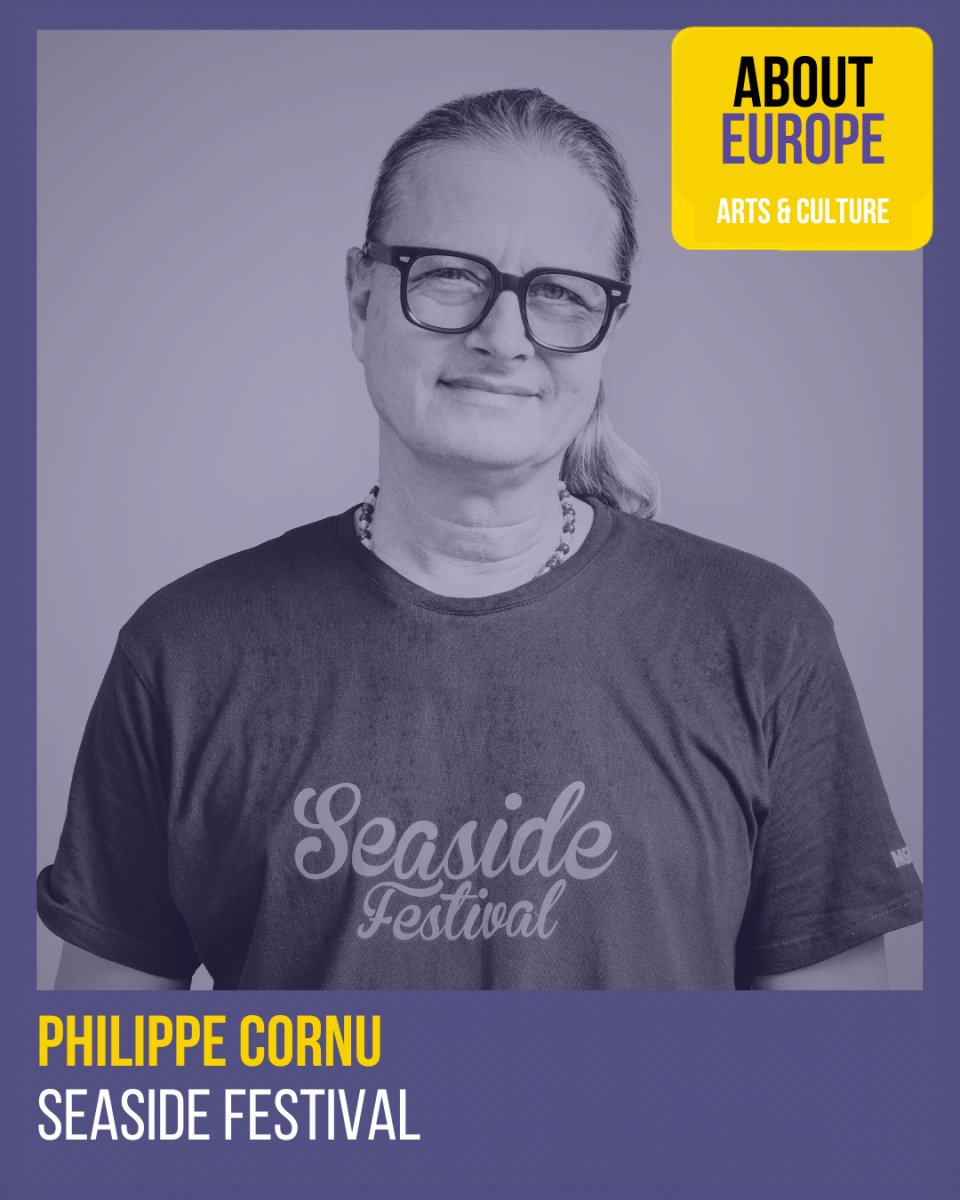 Man with glasses and a ponytail wearing a "Seaside Festival" t-shirt with text identifying Philippe Cornu and Seaside Festival.